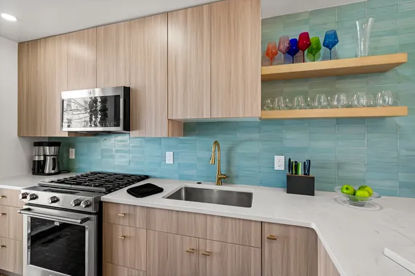 a kitchen with stainless steel appliances a stove a sink and a cabinets