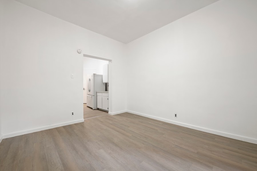 312 West 49th Street, Unit 1RW Manhattan, NY 10019 - Photo 6 of 12 an empty room with wooden floor and windows
