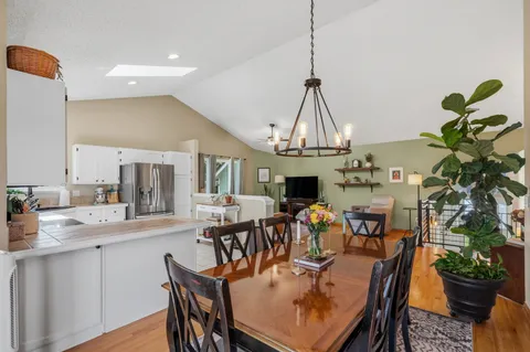 a kitchen with white cabinets stainless steel appliances a sink and a window
