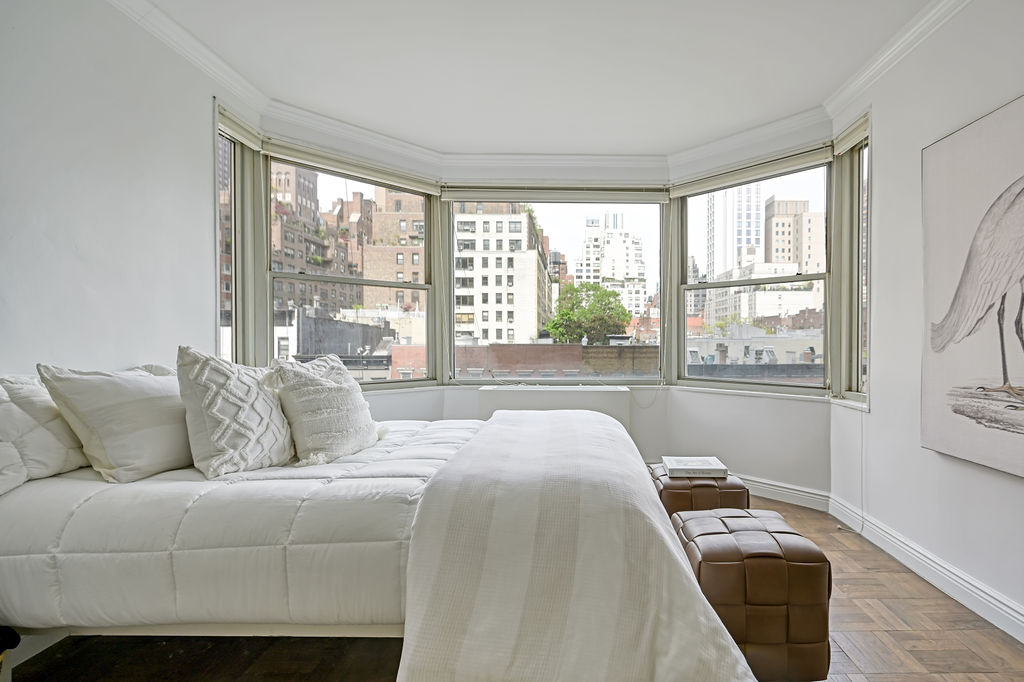 300 East 74th Street, Unit 6D Manhattan, NY 10021 - Photo 3 of 12 a bedroom with a bed and a large window