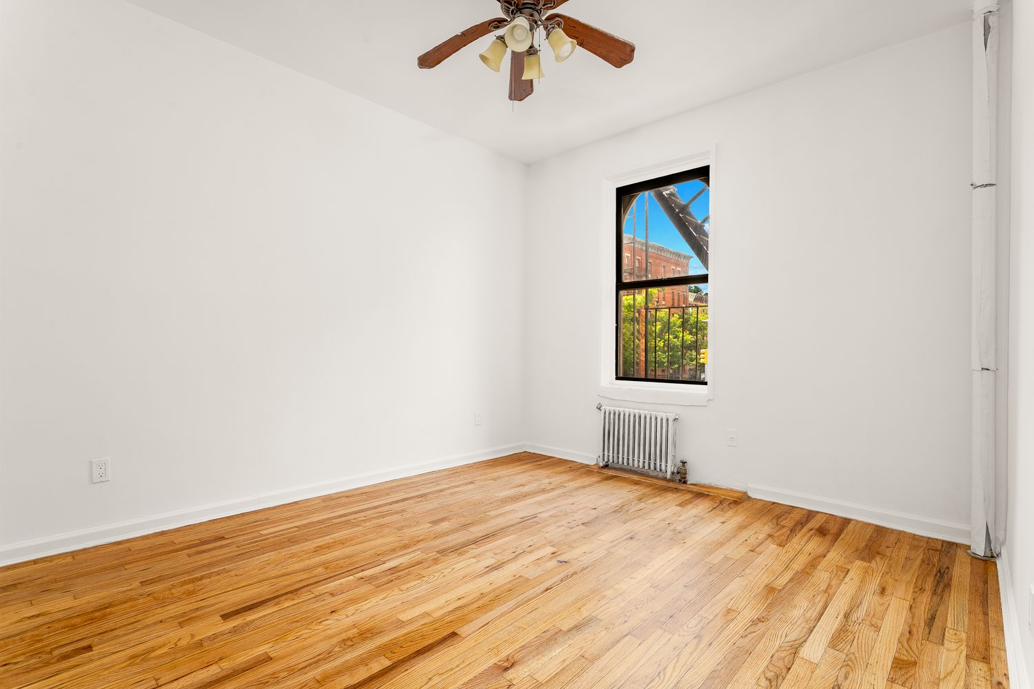 an empty room with a window and wooden floor