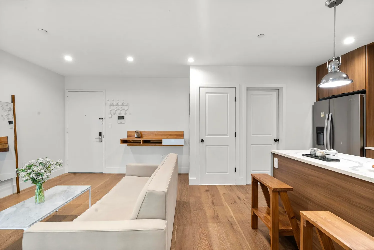 a living room with stainless steel appliances kitchen island granite countertop furniture and a wooden floor