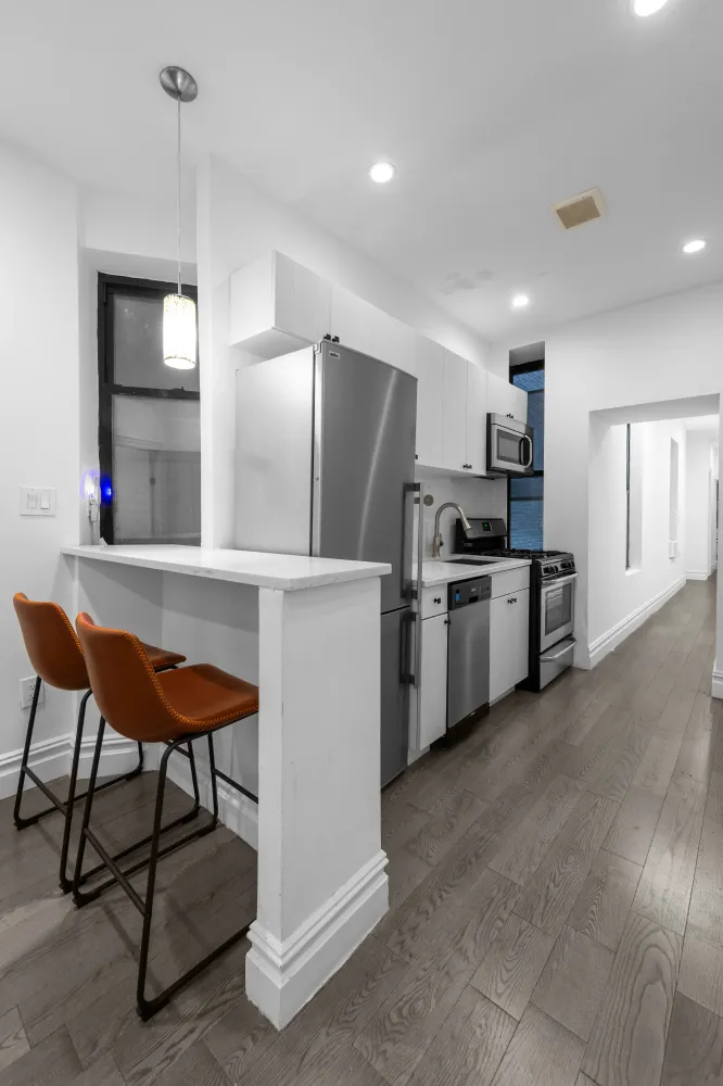 a kitchen with stainless steel appliances kitchen island granite countertop a refrigerator and a stove top oven