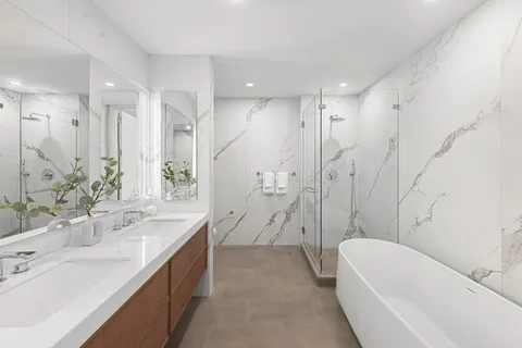 a bathroom with a bathtub double vanity sink and a shower