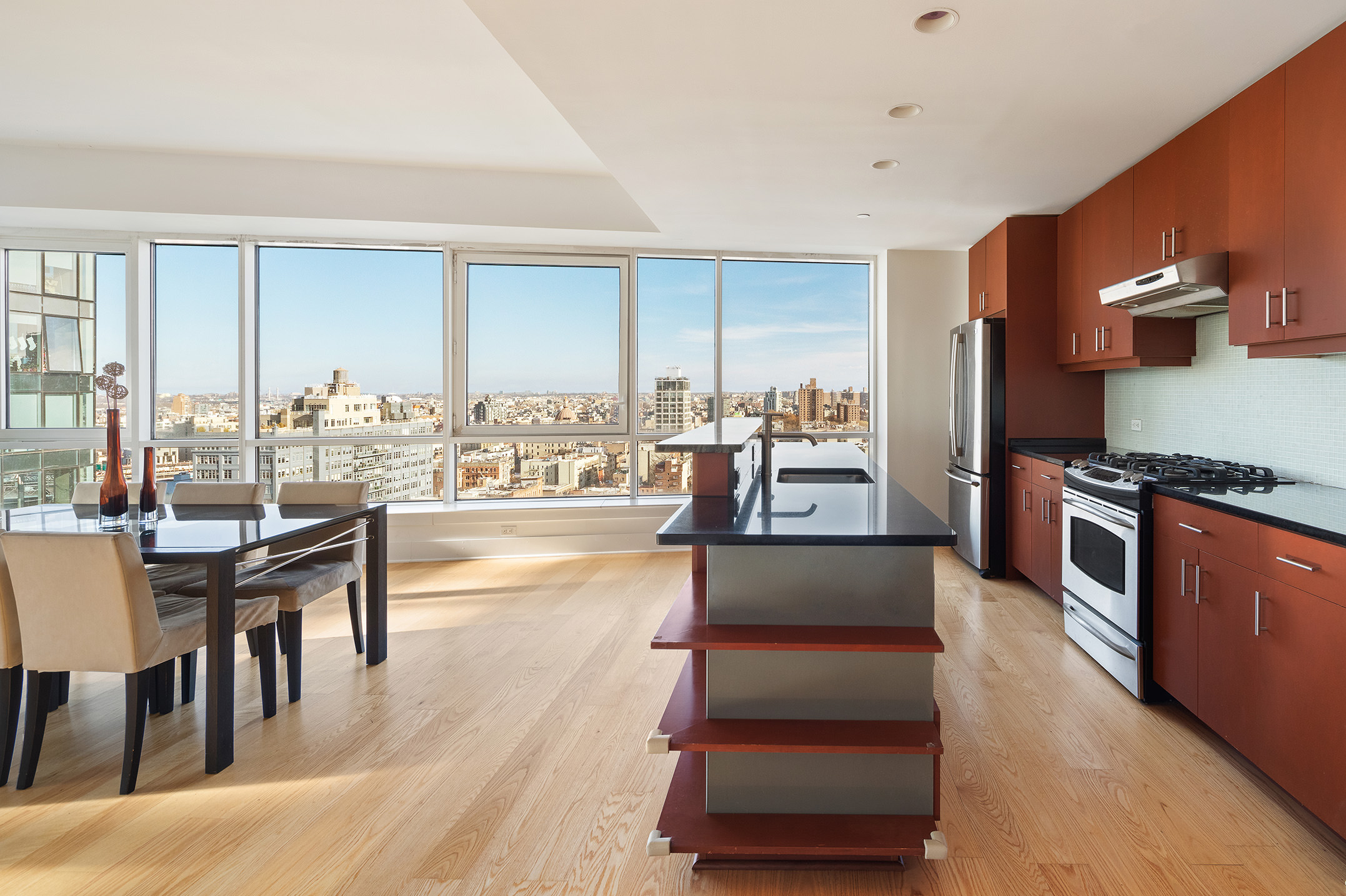 440 Kent Avenue, Unit 22C Brooklyn, NY 11249 - Photo 4 of 14 a living room with couches and kitchen view with wooden floor
