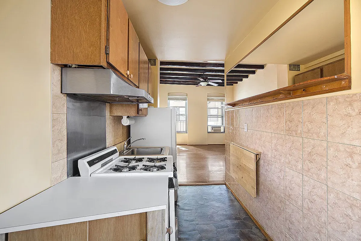 312 West 49th Street, Unit 5RW Manhattan, NY 10019 - Photo 3 of 5 a kitchen with a stove and a refrigerator