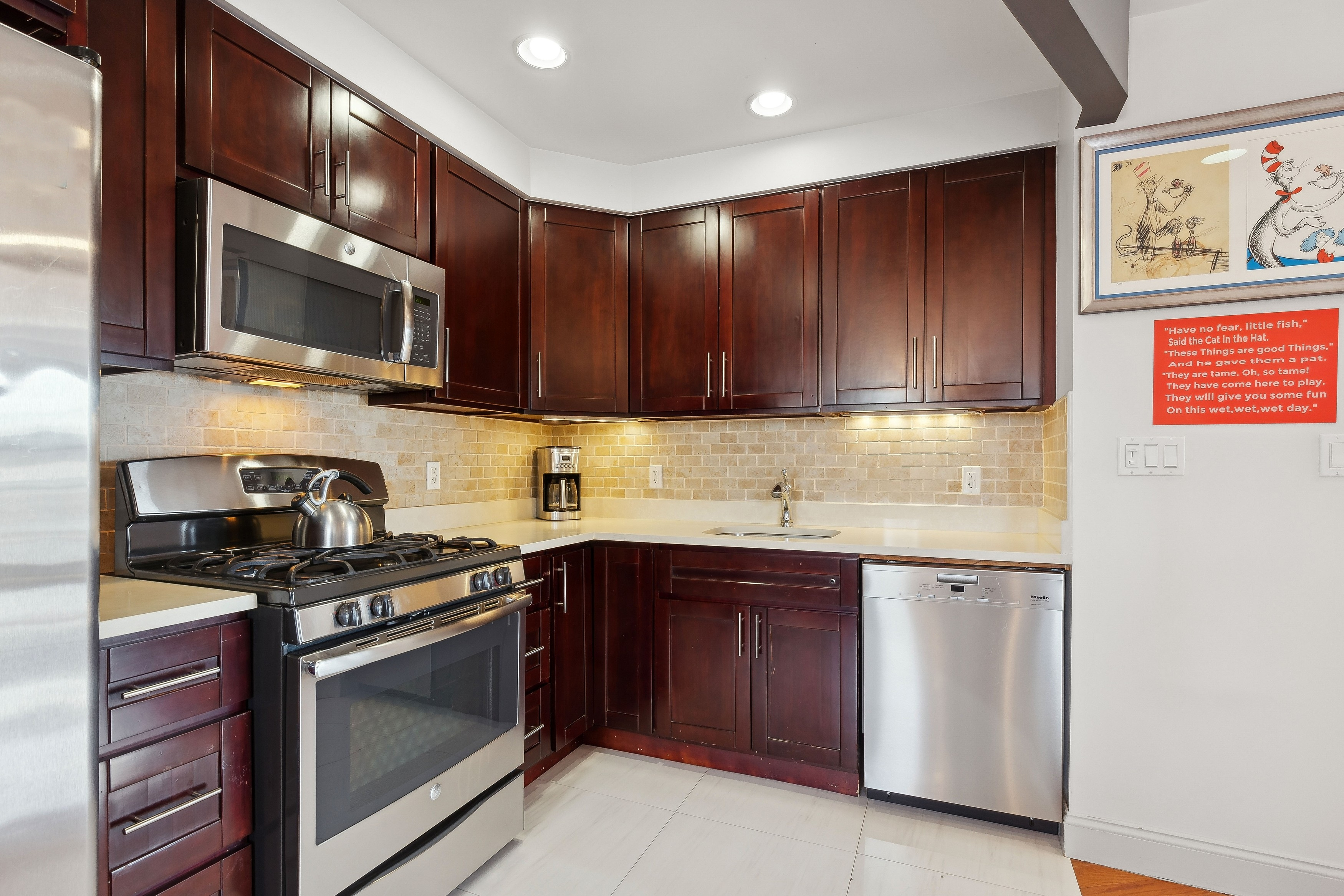 456 West 167th Street, Unit 7C Manhattan, NY 10032 - Photo 7 of 16 a kitchen with stainless steel appliances granite countertop wooden cabinets stove top oven and sink