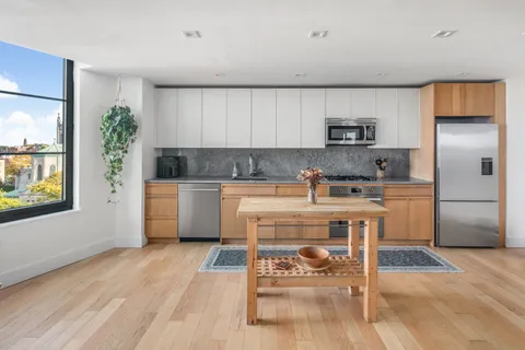a kitchen with a white cabinets and chairs in it