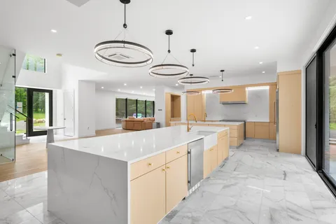 a large kitchen with kitchen island a large counter space and stainless steel appliances