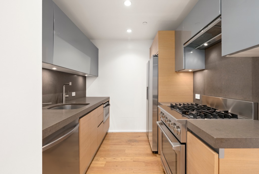 2280 Frederick Douglass Boulevard, Unit 6A Manhattan, NY 10027 - Photo 5 of 13 a kitchen with stainless steel appliances granite countertop a sink stove and refrigerator