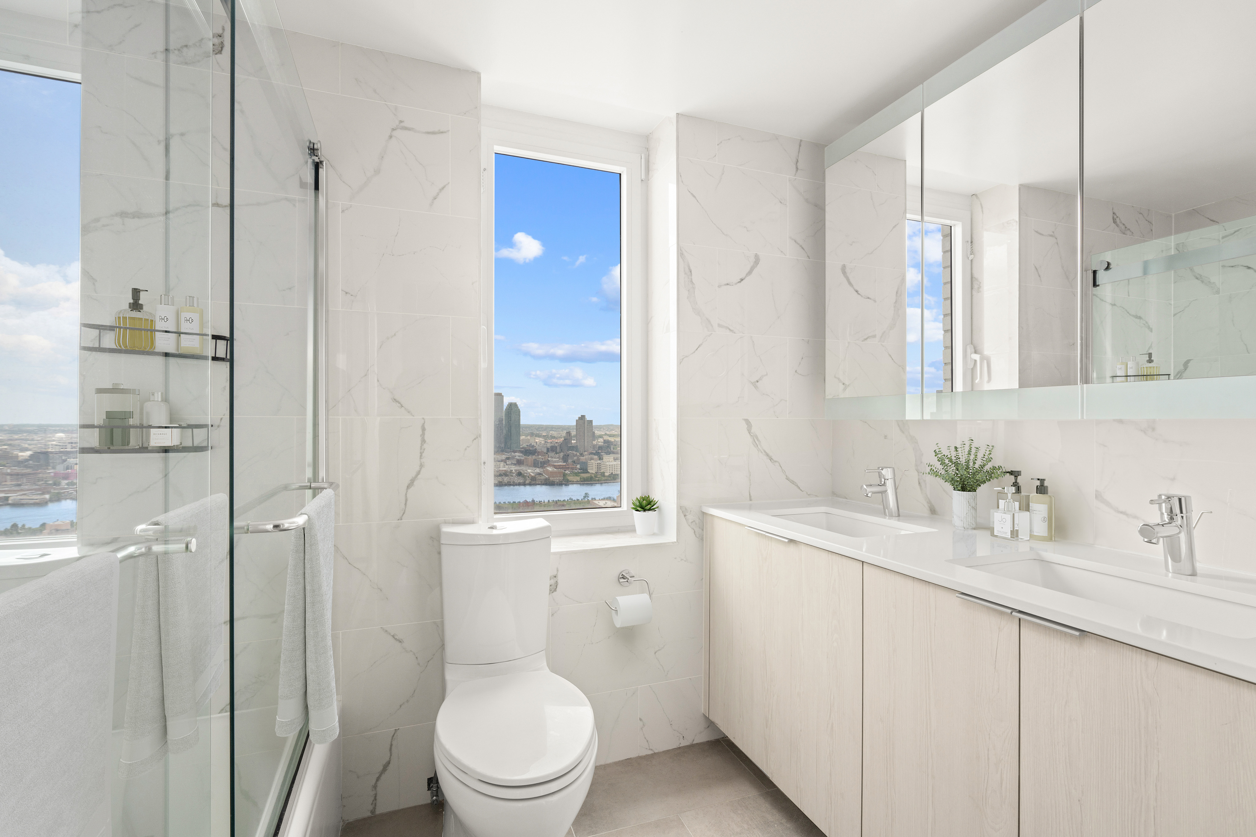 303 East 57th Street, Unit 41G Manhattan, NY 10022 - Photo 10 of 15 a bathroom with a sink a toilet and shower