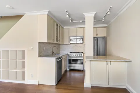 a view of an empty room with wooden floor and entryway