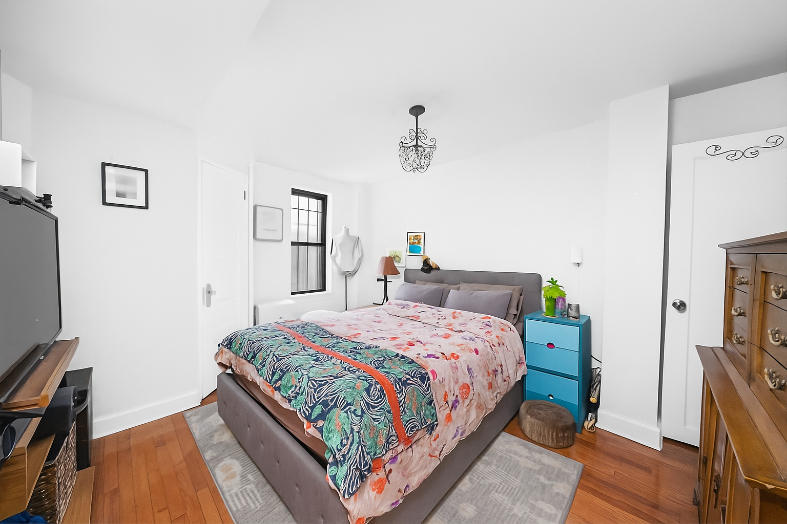 292 Windsor Place, Unit GARDEN Brooklyn, NY 11218 - Photo 4 of 7 a bedroom with a bed table and a flat tv screen