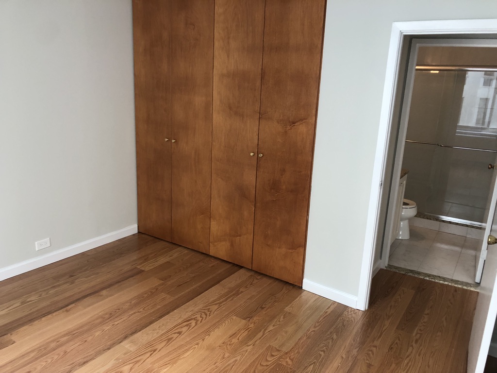 61 West 62nd Street, Unit 7C Manhattan, NY 10023 - Photo 5 of 7 a view of an empty room with wooden floor and a window