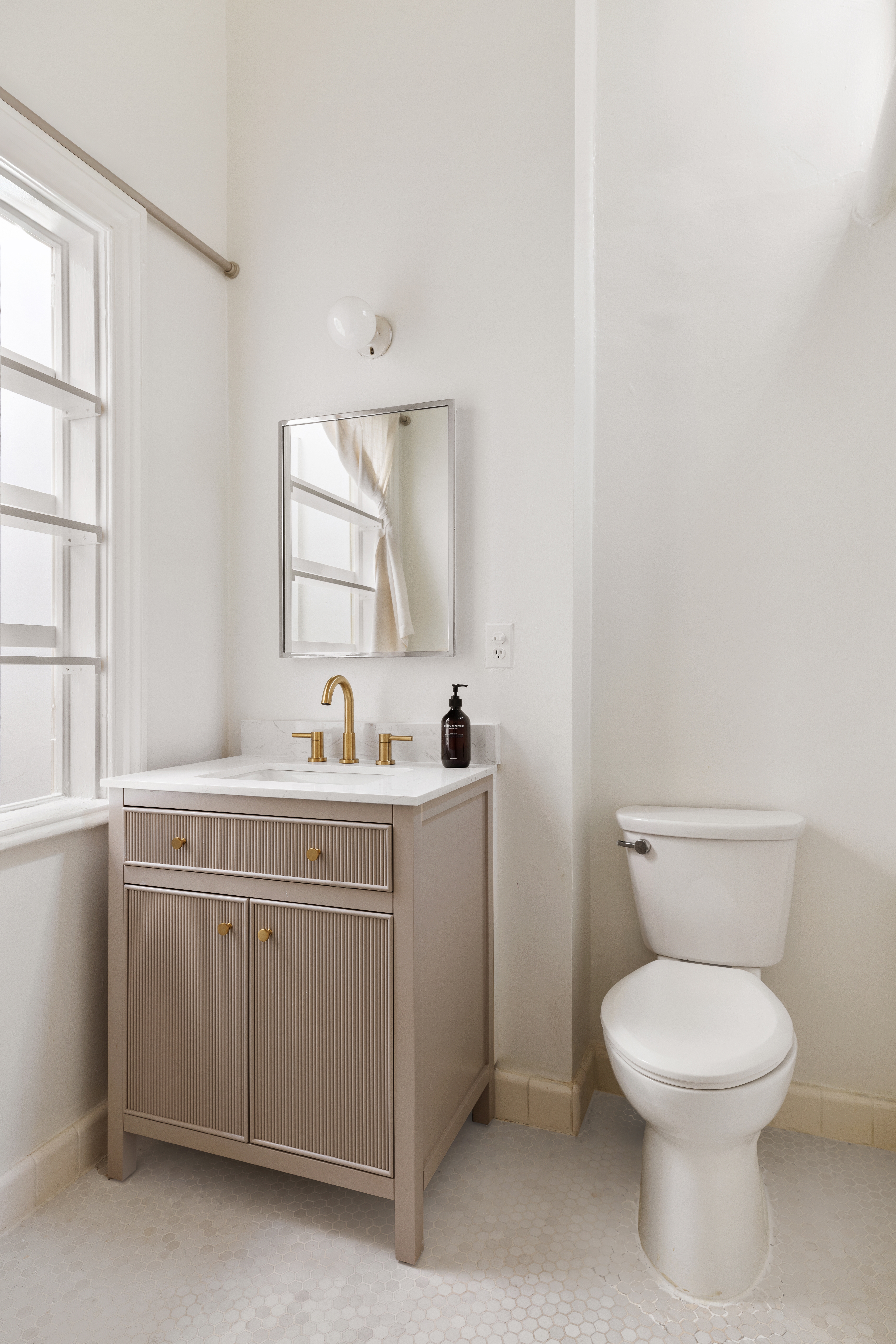 266 Henry Street, Unit B Brooklyn, NY 11201 - Photo 12 of 17 a bathroom with a toilet a sink a mirror and a window