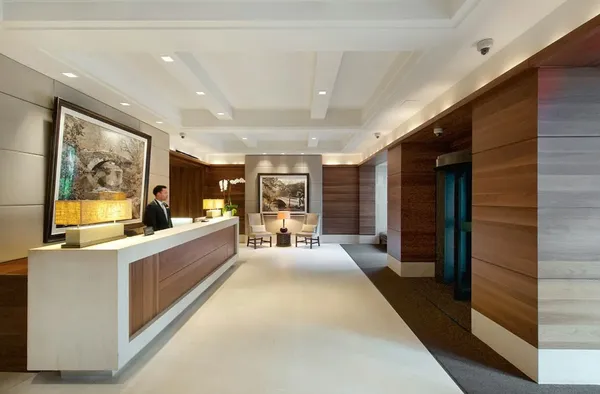 a large living room with stainless steel appliances kitchen island granite countertop a large window and a couch