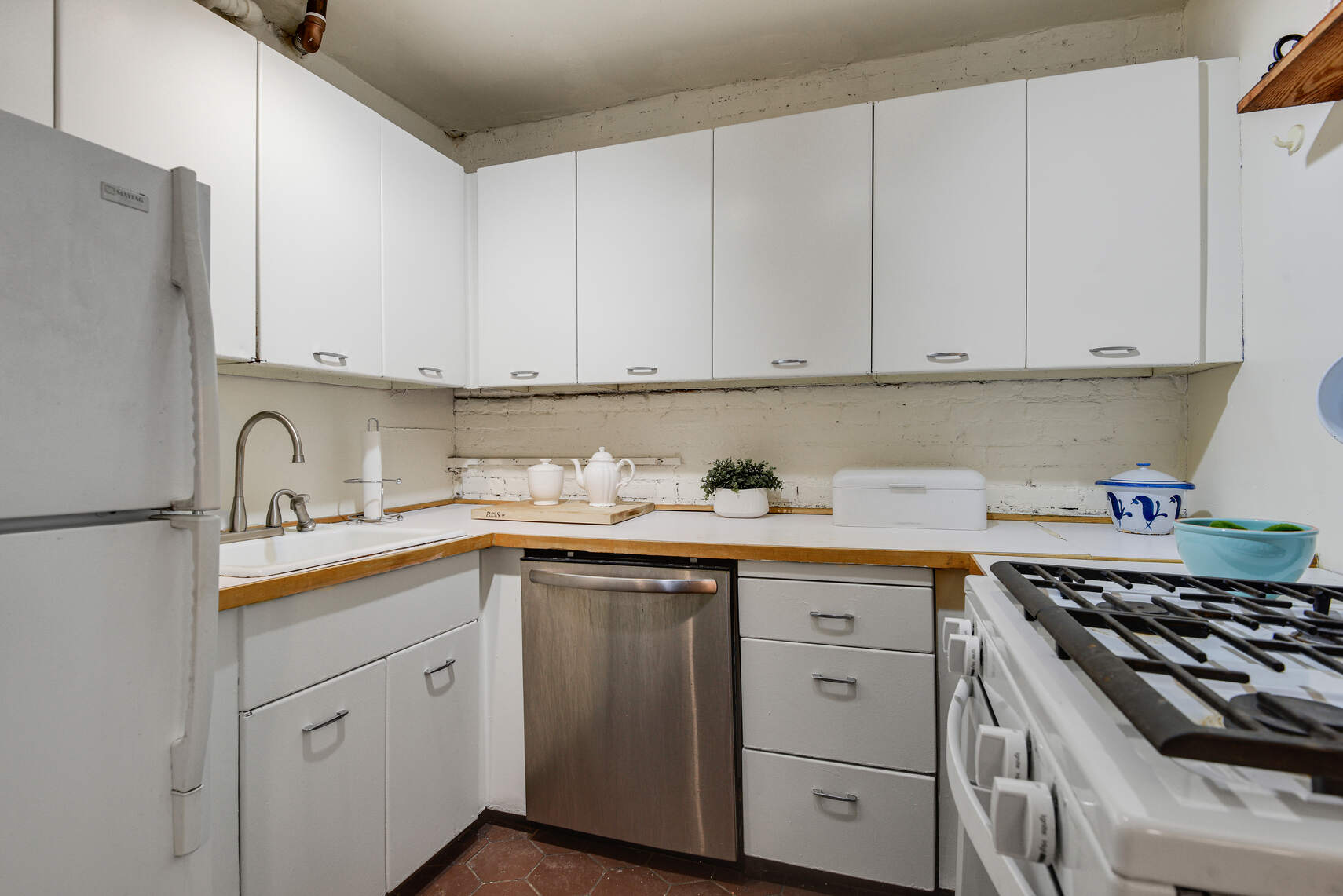 217 West 15th Street Manhattan, NY 10011 - Photo 11 of 21 a kitchen with white cabinets and white appliances