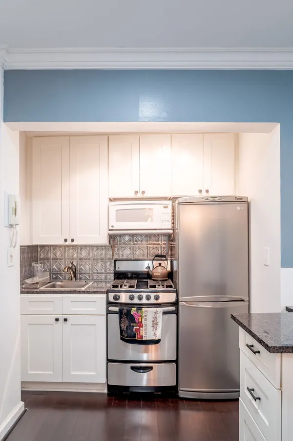a white refrigerator freezer and a stove sitting inside of a kitchen