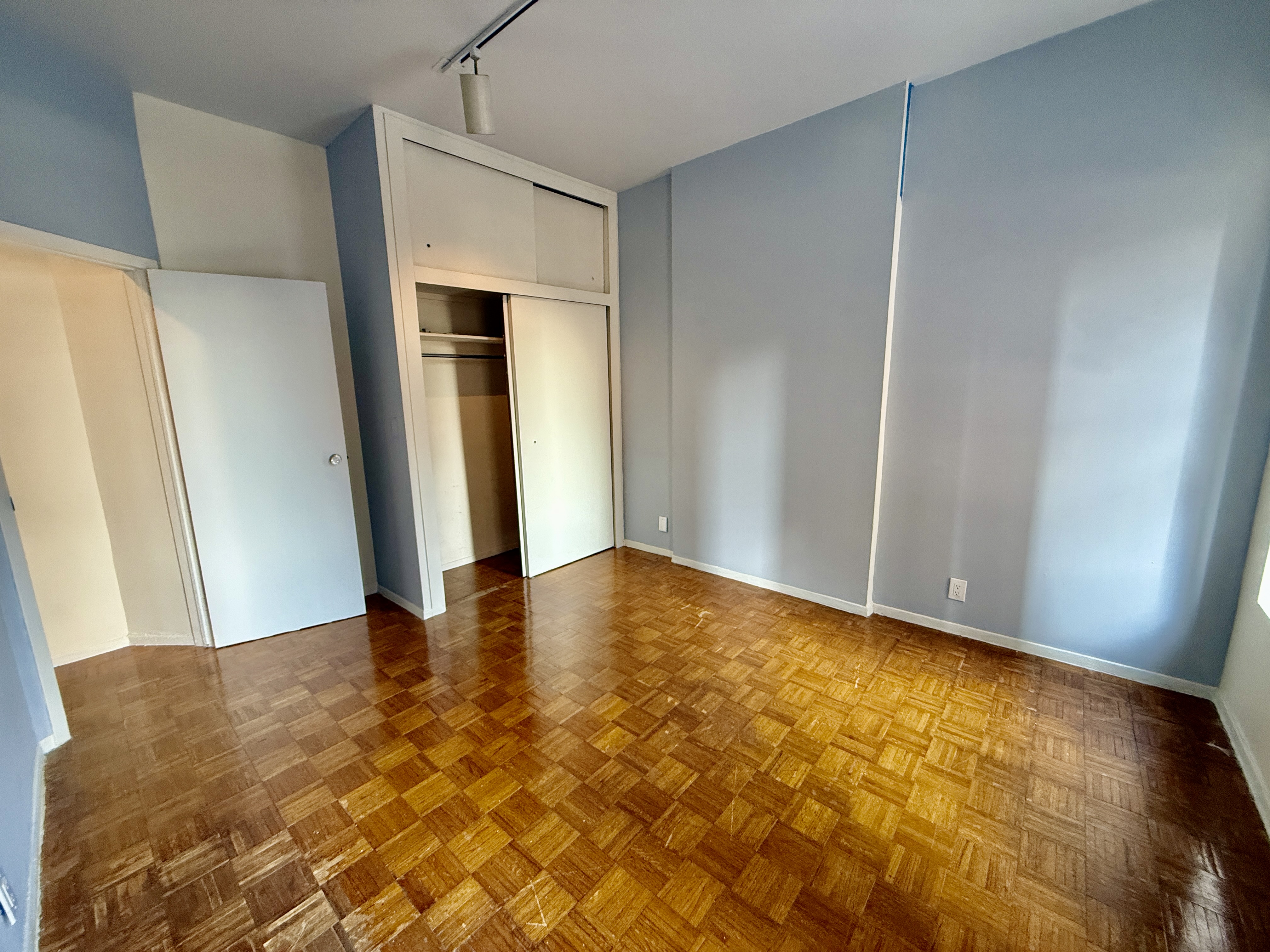 344 East 61st Street, Unit 16 Manhattan, NY 10065 - Photo 2 of 8 a view of an empty room with wooden floor and a window