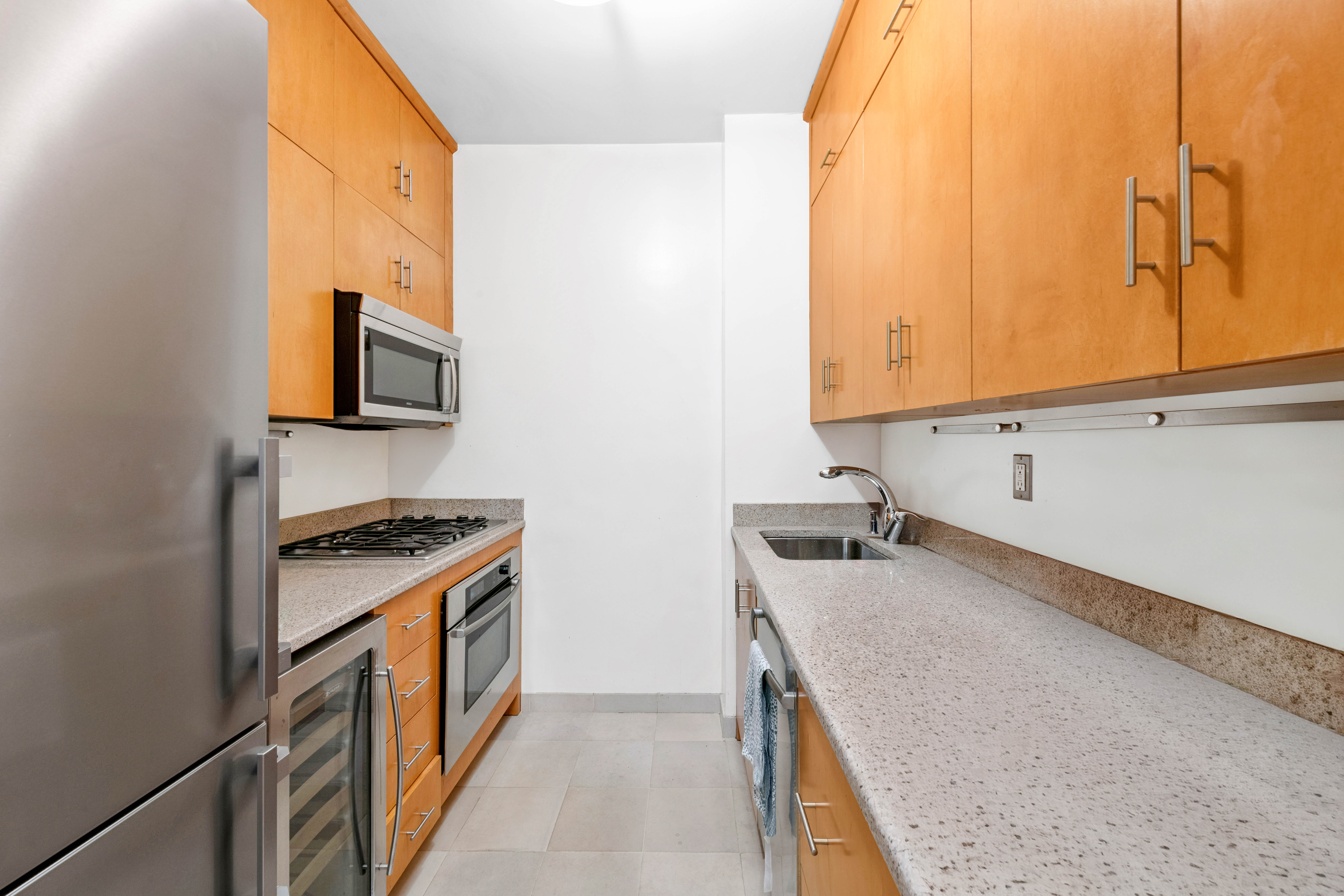 200 East 69th Street, Unit 4N Manhattan, NY 10021 - Photo 6 of 13 a kitchen with stainless steel appliances granite countertop a sink and a stove