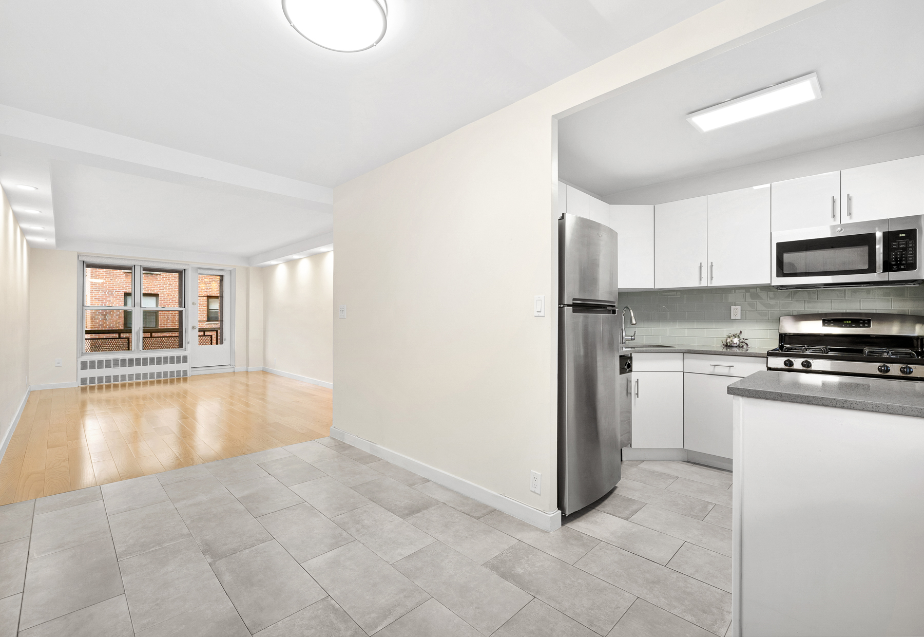 35-11 85th Street, Unit 4F Queens, NY 11372 - Photo 5 of 10 a large kitchen with cabinets and stainless steel appliances