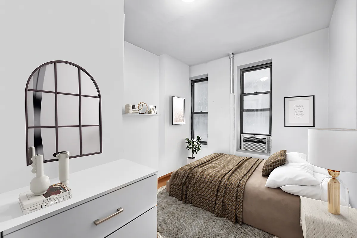 142 Sullivan Street, Unit 19 Manhattan, NY 10012 - Photo 6 of 11 a bedroom with a bed and a large mirror