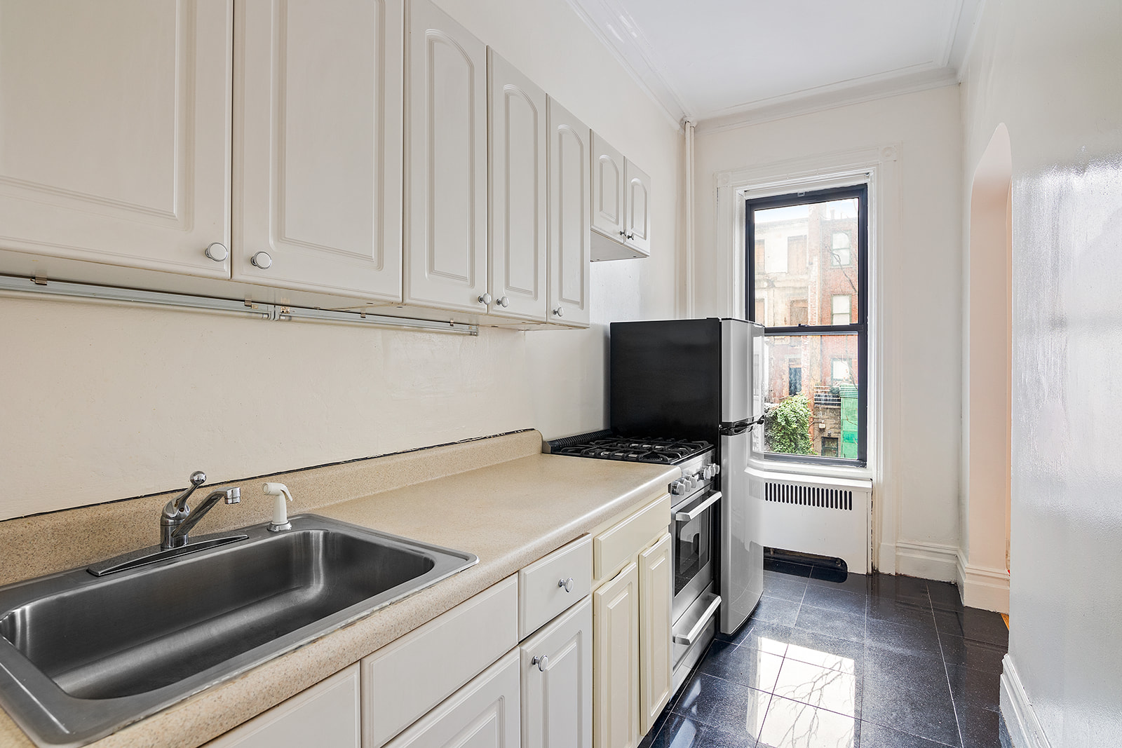65 East 80th Street, Unit 3B Manhattan, NY 10075 - Photo 3 of 5 a kitchen with a sink and a refrigerator