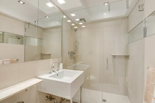 a bathroom with a sink shower and a mirror