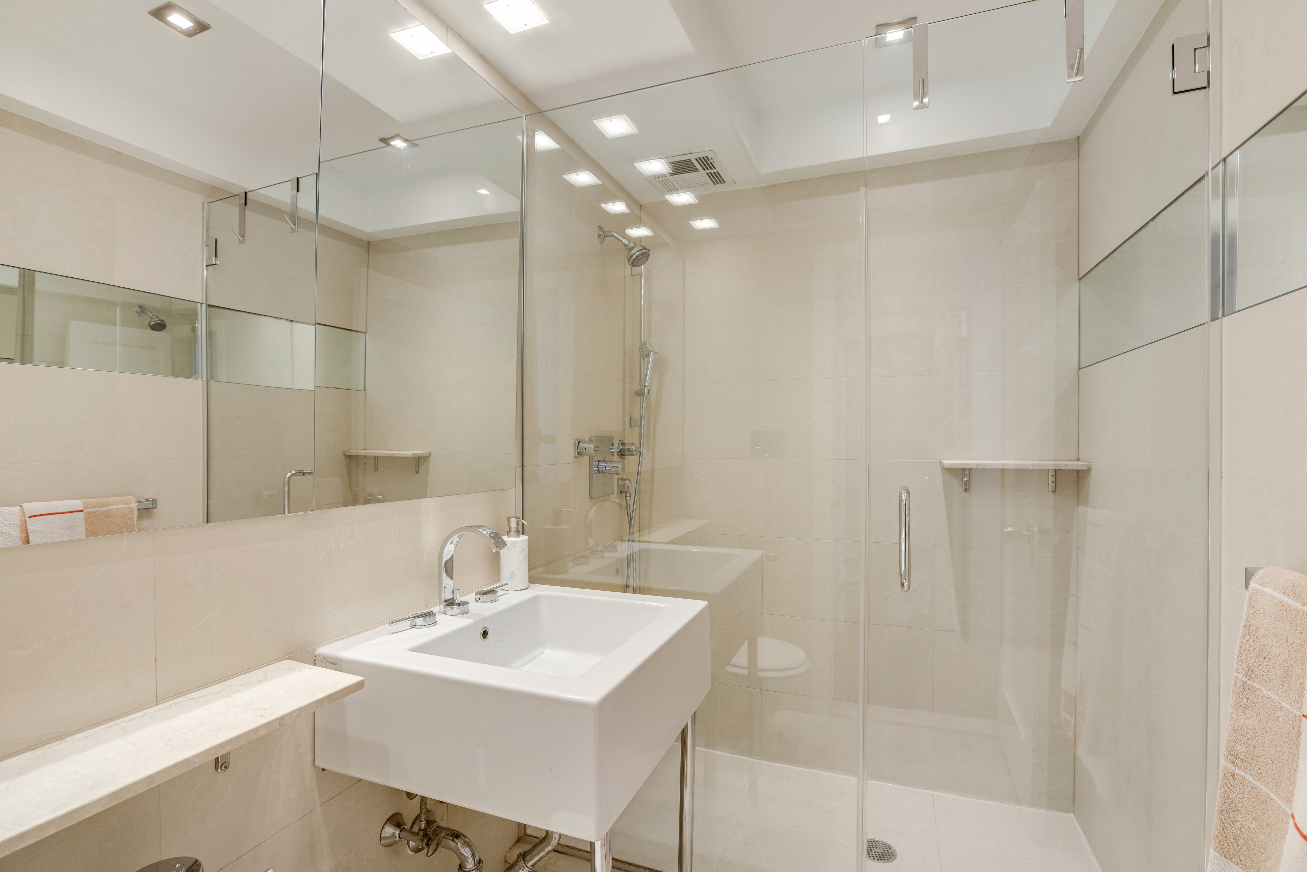 340 West 57th Street, Unit 8E Manhattan, NY 10019 - Photo 8 of 16 a bathroom with a sink shower and a mirror