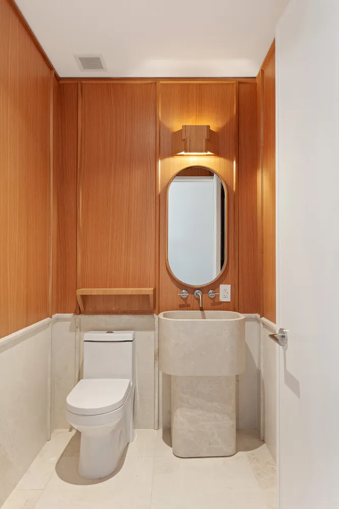 a bathroom with a toilet a sink and mirror