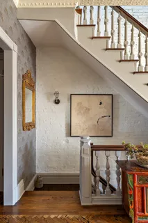 a view of an empty room with wooden floor fireplace and a window