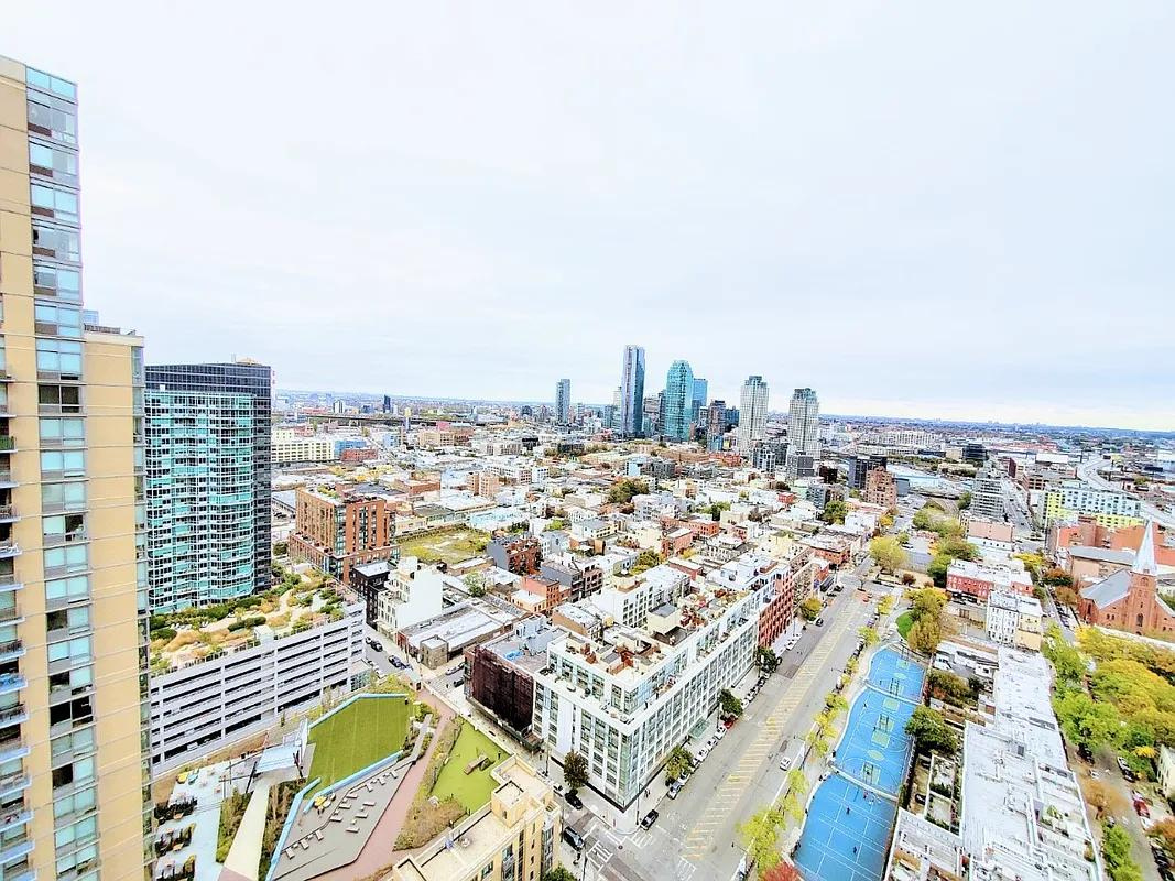 4-74 48th Avenue, Unit 34G Queens, NY 11109 - Photo 2 of 9 a view of city with tall buildings