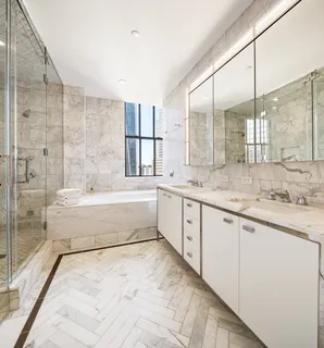 a spacious bathroom with a granite countertop sink mirror and a bathtub
