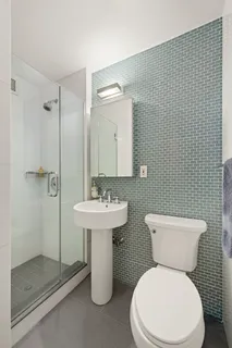 a white toilet sitting next to a bathroom sink
