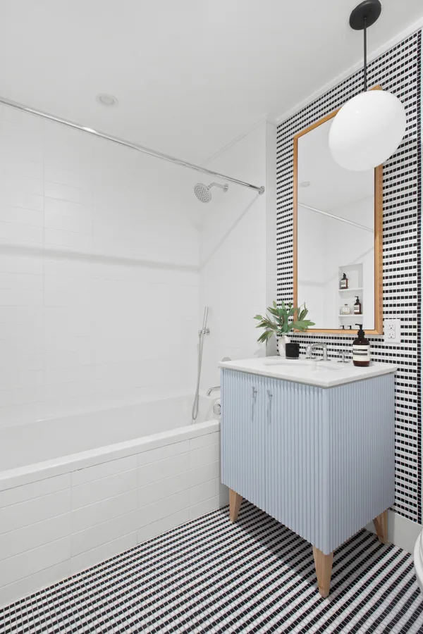 a bathroom with a bathtub a sink and a mirror