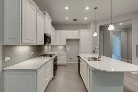 a kitchen with kitchen island a sink stainless steel appliances and cabinets