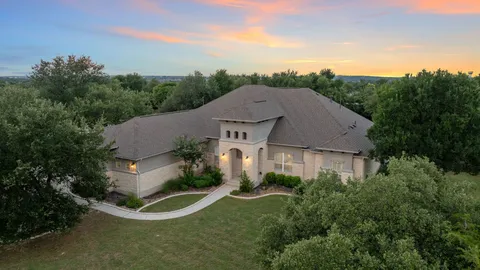 an aerial view of a house with a yard and trees