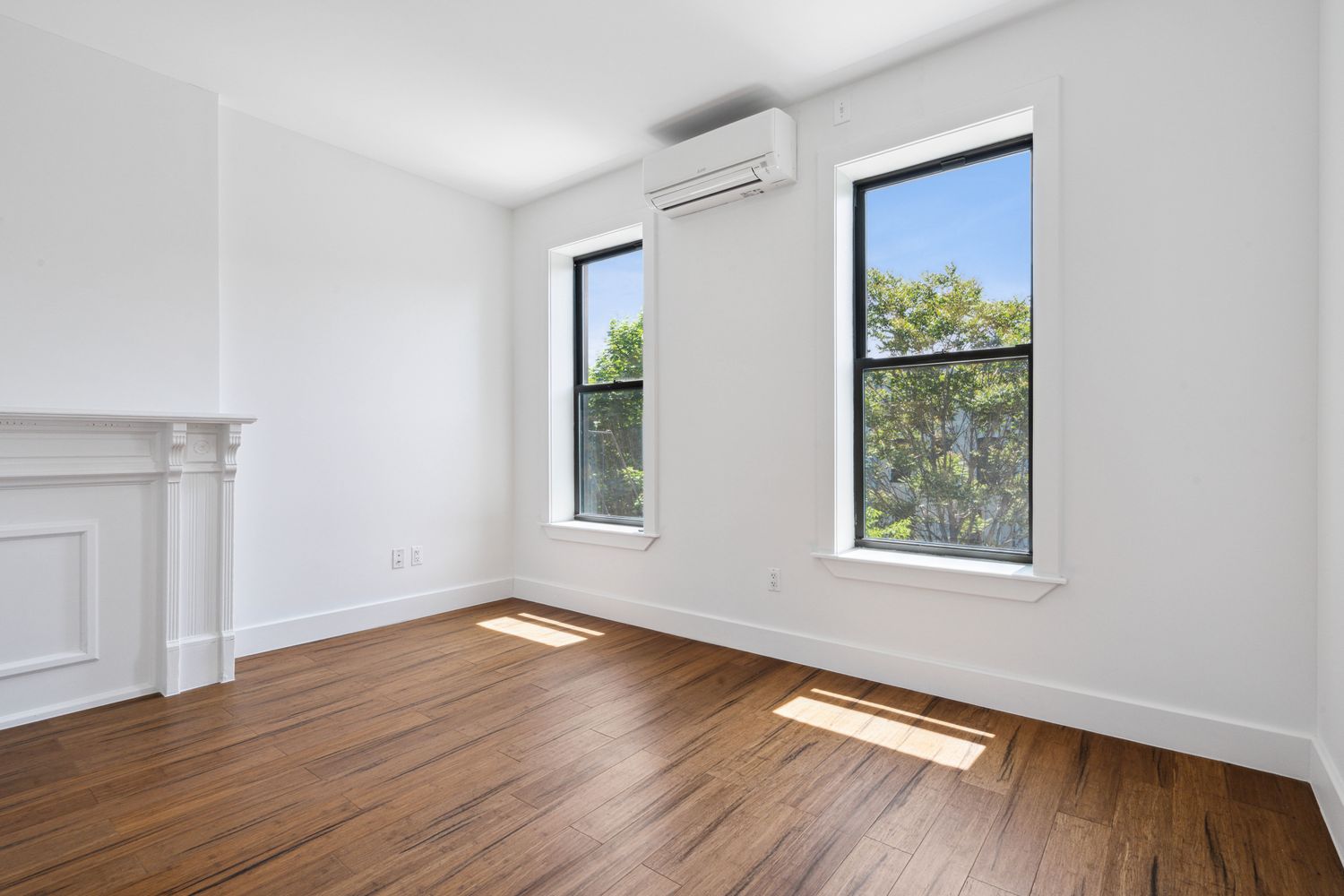 692 Putnam Avenue, Unit 2 Brooklyn, NY 11221 - Photo 4 of 15 an empty room with wooden floor and windows