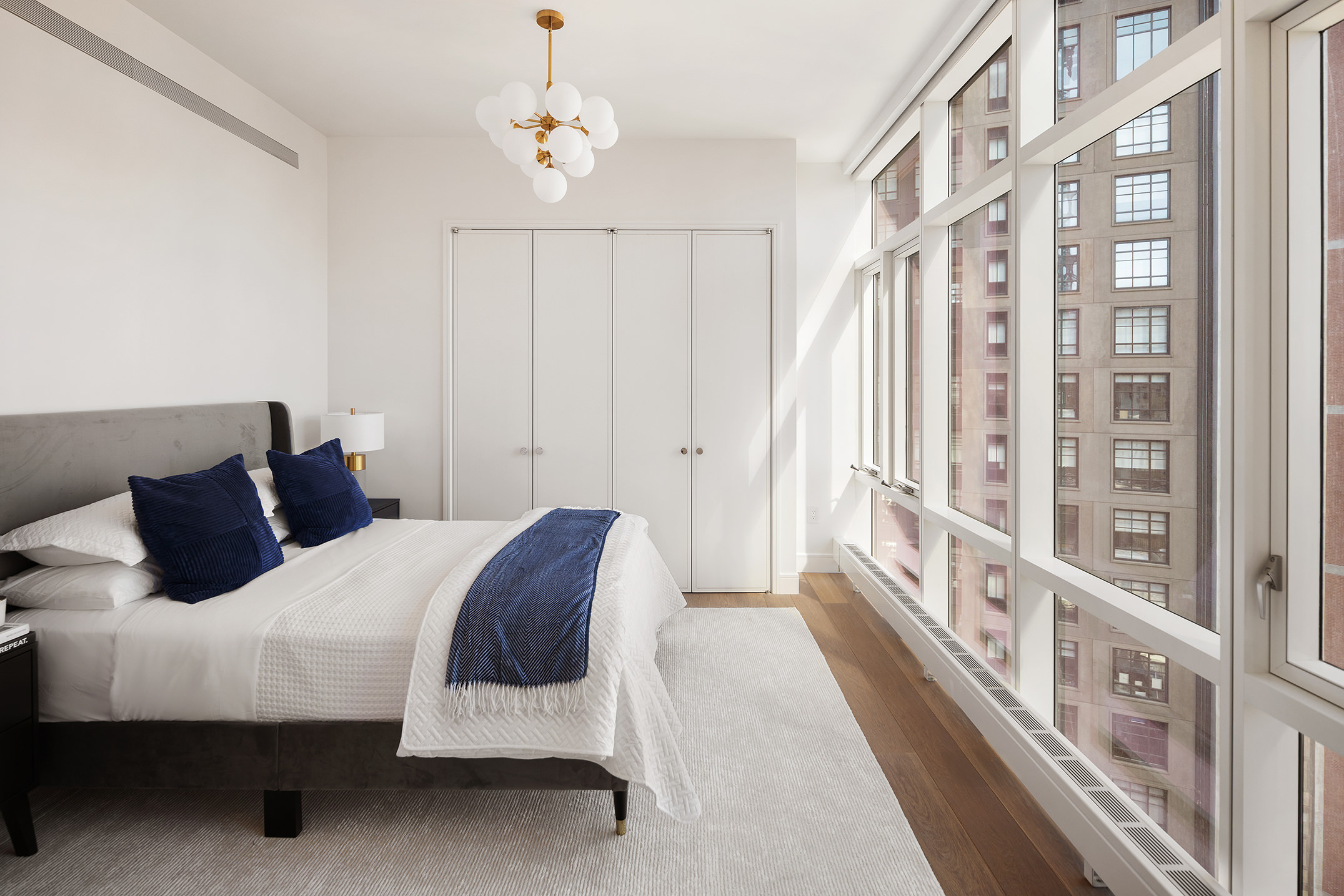 5 Beekman Street, Unit 21B Manhattan, NY 10038 - Photo 9 of 23 a bedroom with a large bed and a chandelier