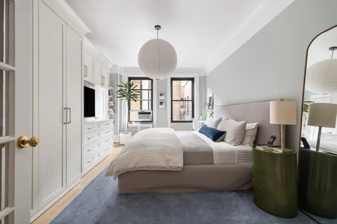 a bedroom with bed and a chandelier