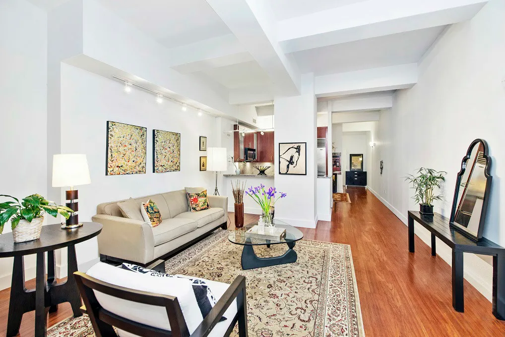 a living room with furniture fireplace and wooden floor