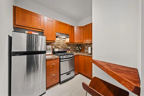a kitchen with stainless steel appliances granite countertop a refrigerator stove and sink