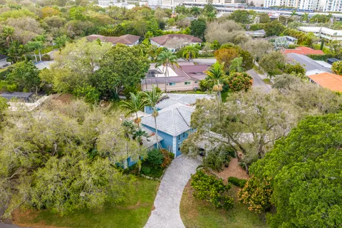 an aerial view of residential house with outdoor space and trees all around