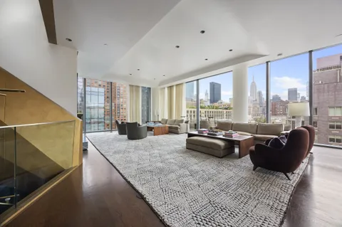 a living room with furniture and floor to ceiling window