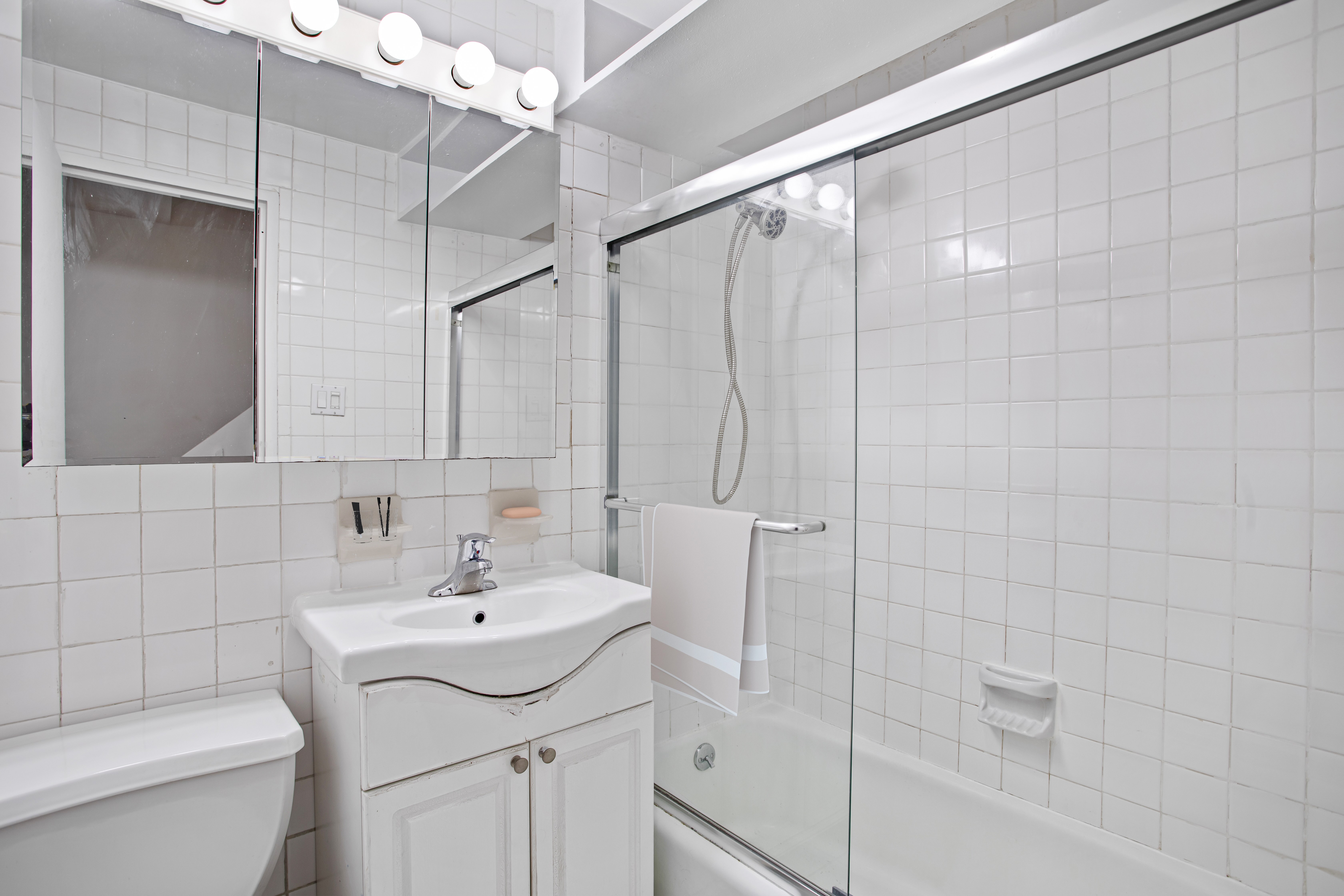 435 East 86th Street, Unit 2C Manhattan, NY 10028 - Photo 7 of 10 a bathroom with a sink a toilet and shower