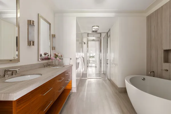 a spacious bathroom with a tub sink shower and mirror