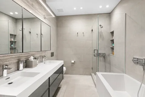 a spacious bathroom with a bathtub sink mirror and shower