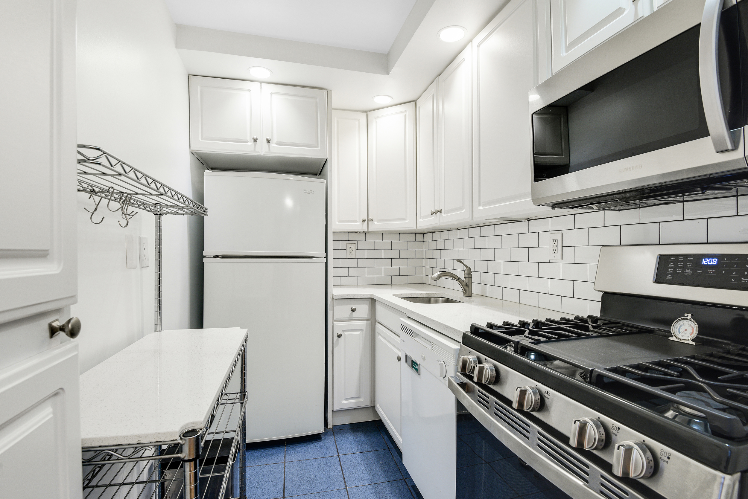520 East 72nd Street, Unit 10P Manhattan, NY 10021 - Photo 8 of 13 a kitchen with a stove a sink and a microwave