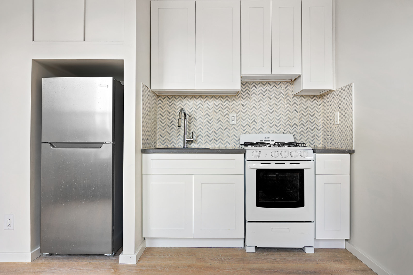 108 Stanton Street, Unit 5D Manhattan, NY 10002 - Photo 2 of 6 a kitchen with cabinets and stainless steel appliances