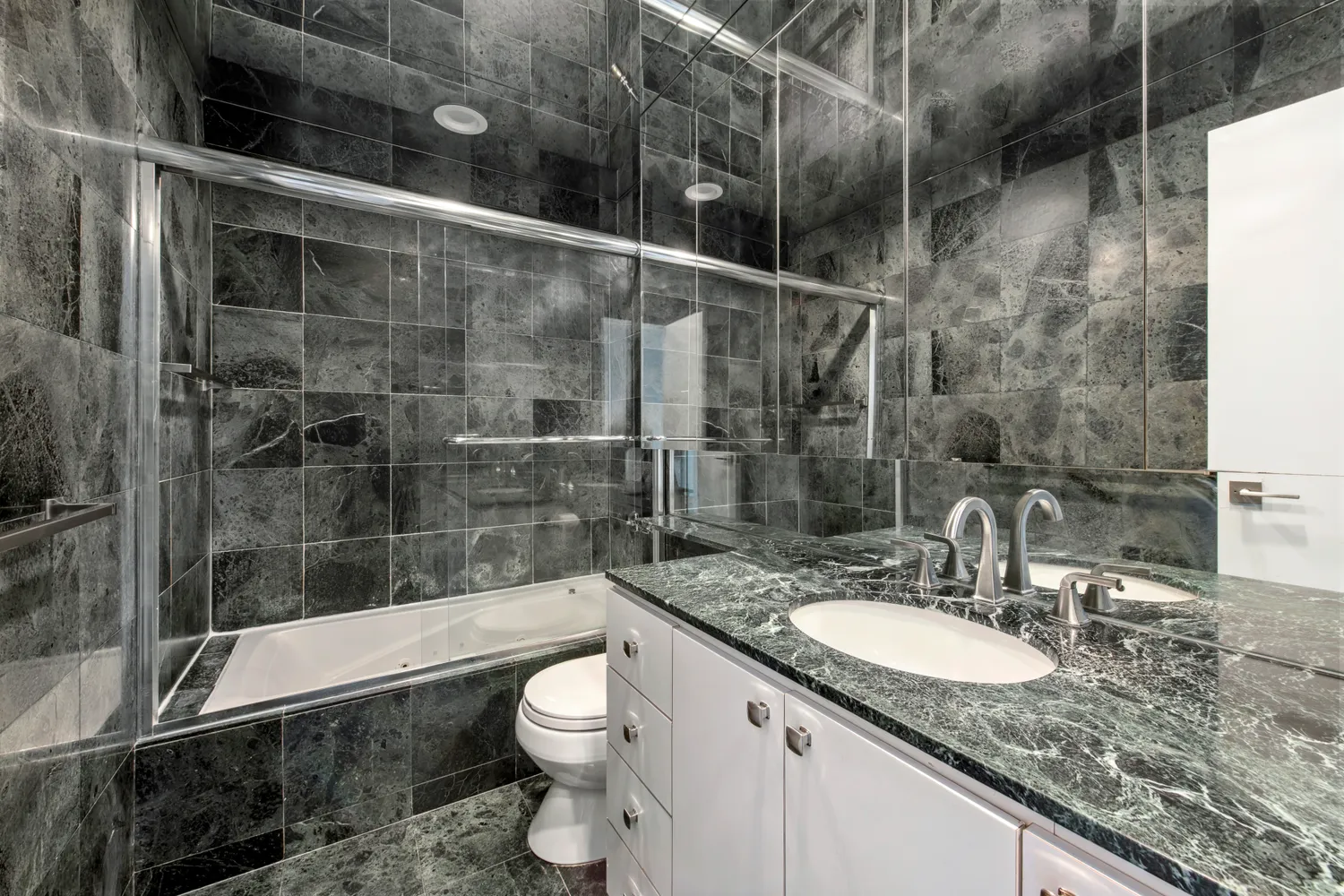 a bathroom with a granite countertop sink a toilet and shower